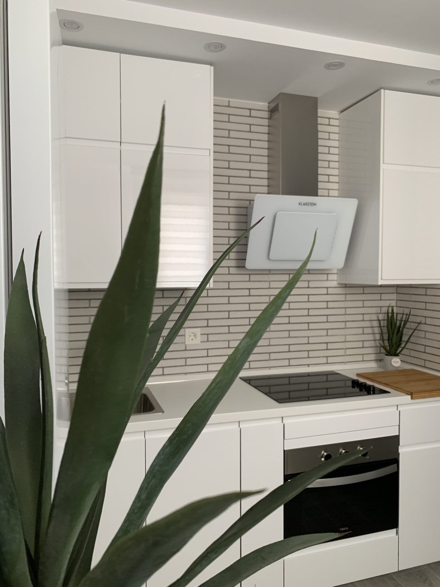 Cocina equipada vista desde arriba — vitrocerámica y encimera blanca