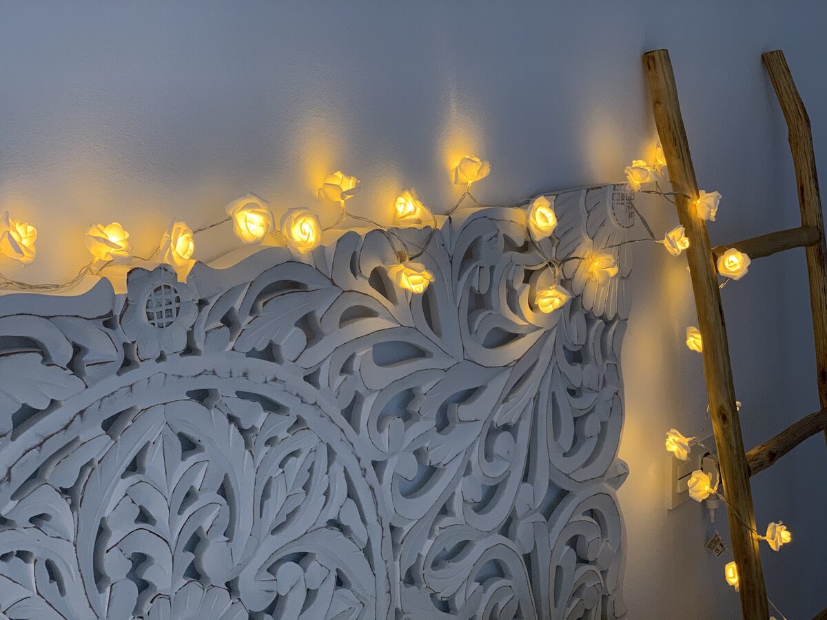 Interior AlmaDeConil — cabecero tallado con luces de hada