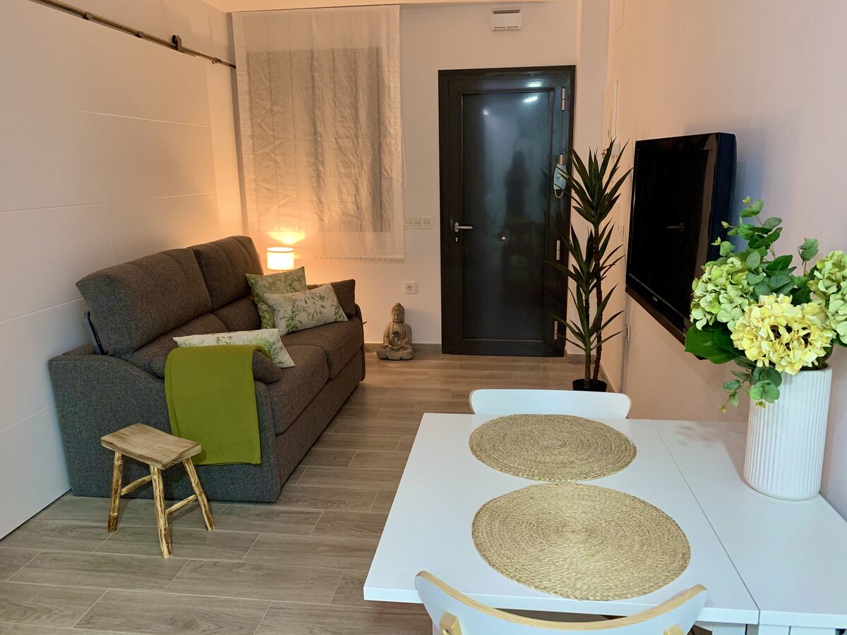 Salón acogedor con sofá y zona de comedor
