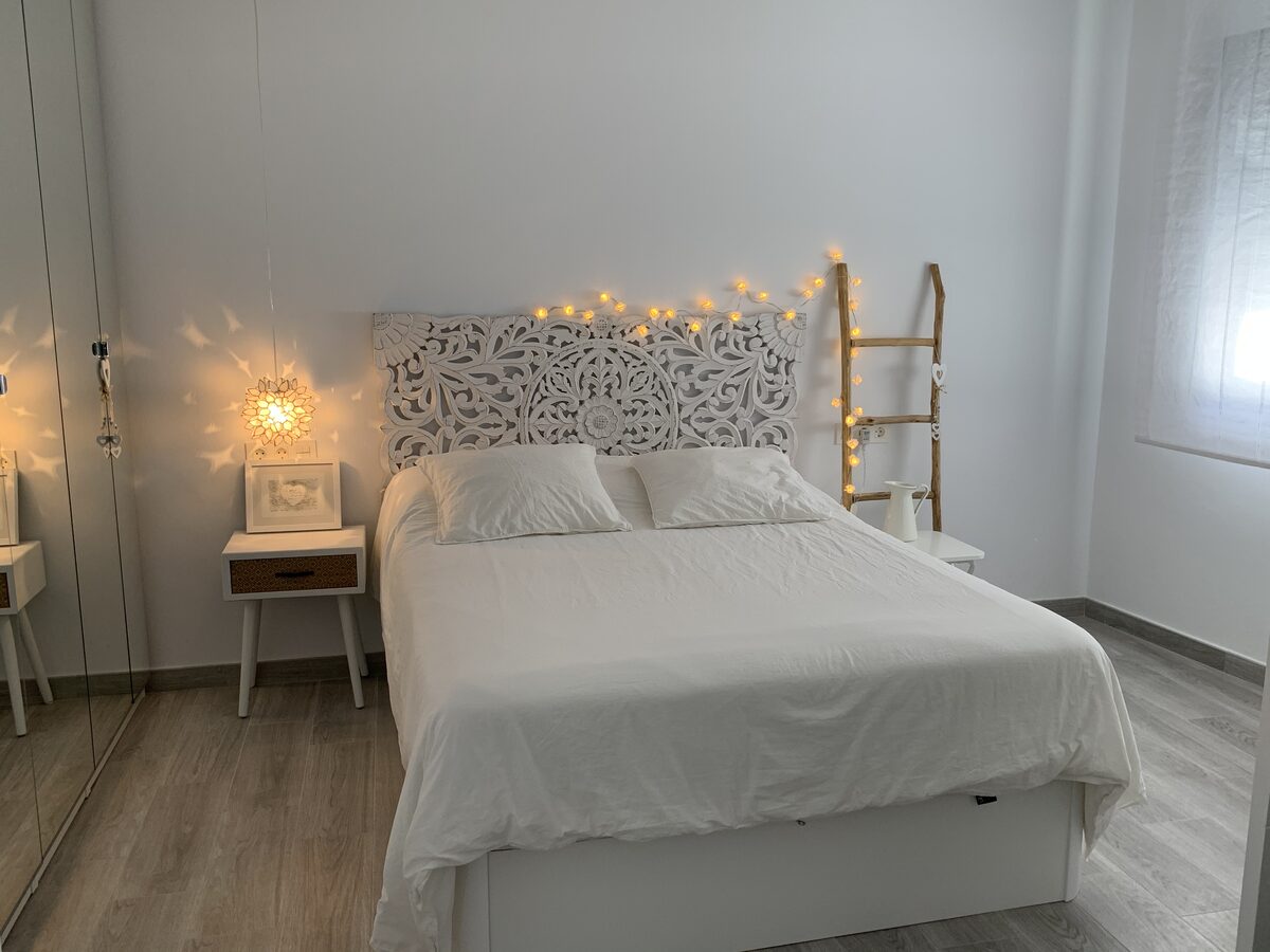 Dormitorio con cabecero tallado y luces de hada